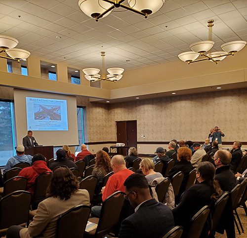 People seated, listening to speaker